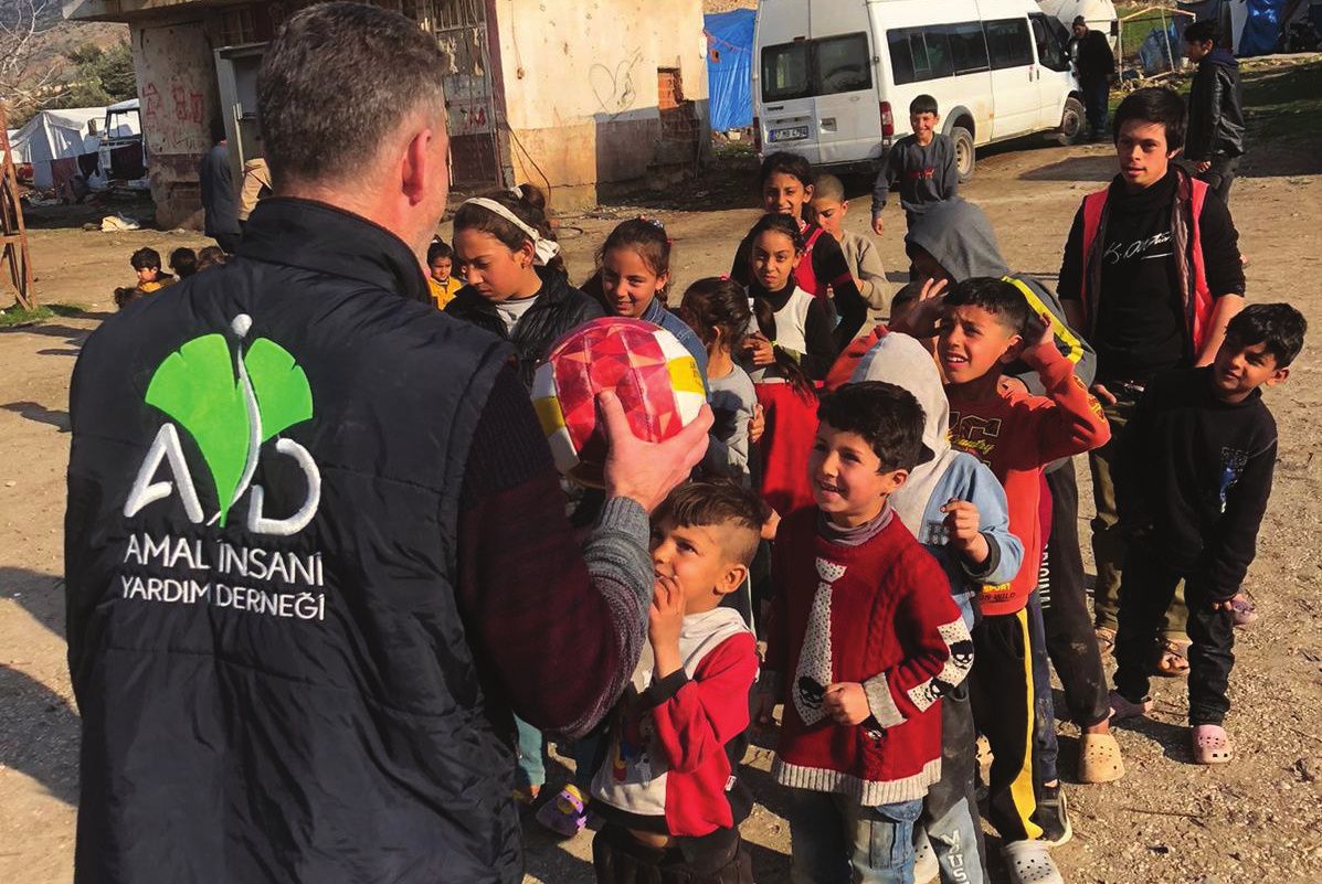 An AİYD team member with children during an activity